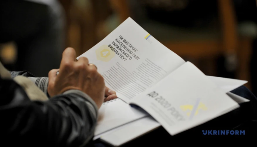 Емблема Міністерства енергетики на тлі газової та електричної інфраструктури