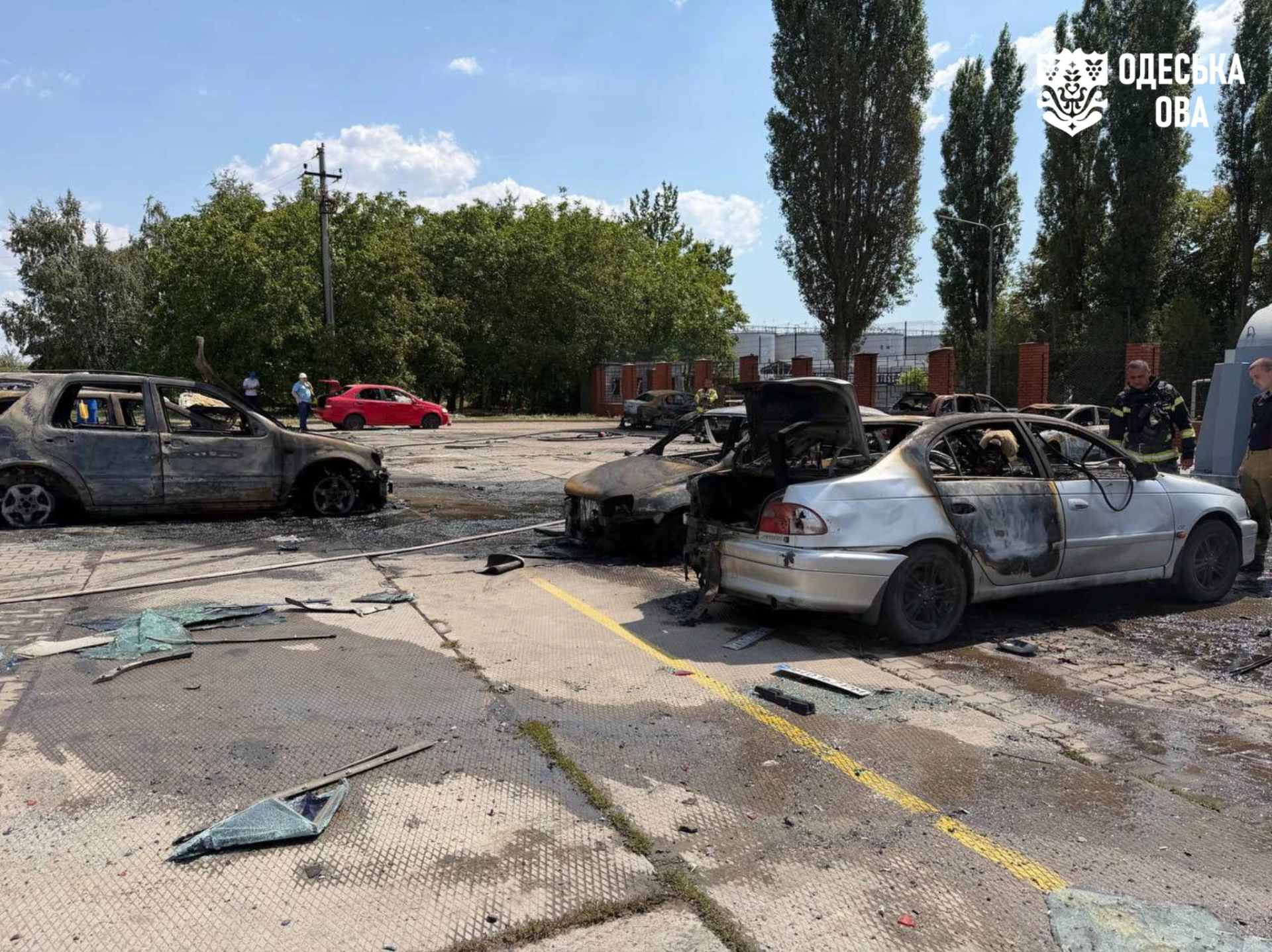 Згорілі автомобілі на стоянці підприємства, пошкоджена будівля та рятувальники на місці удару в Одеському районі 5 серпня